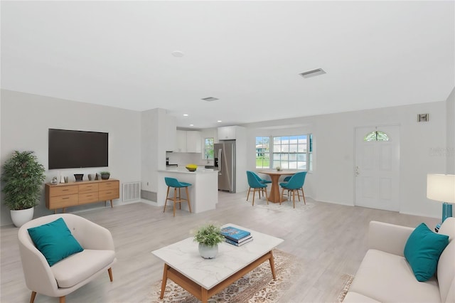 living room with recessed lighting, visible vents, and light wood-style flooring