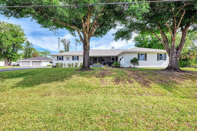 single story home with a detached garage and a front lawn