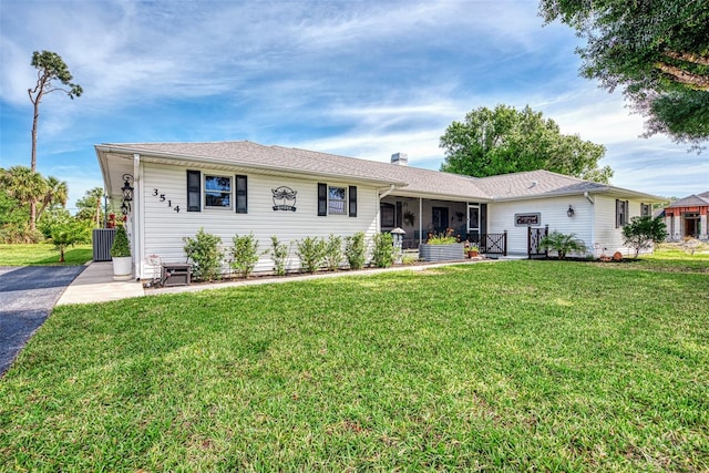 view of front of property with a front yard and central AC