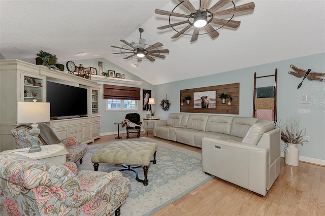 living room with baseboards, ceiling fan, vaulted ceiling, light wood-style flooring, and a textured ceiling