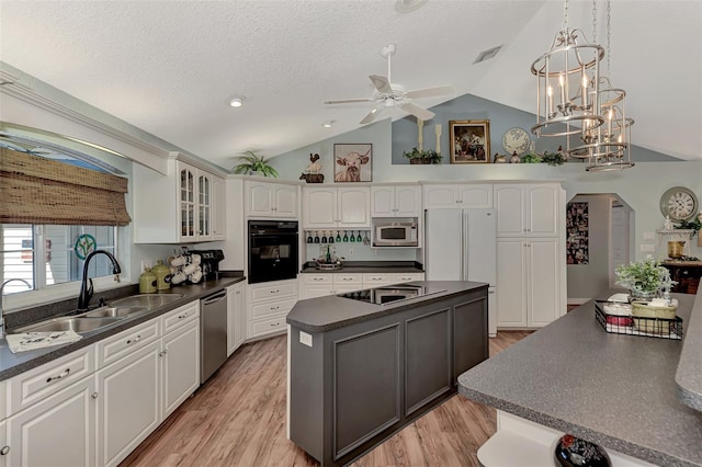 kitchen with visible vents, black appliances, dark countertops, a center island, and glass insert cabinets