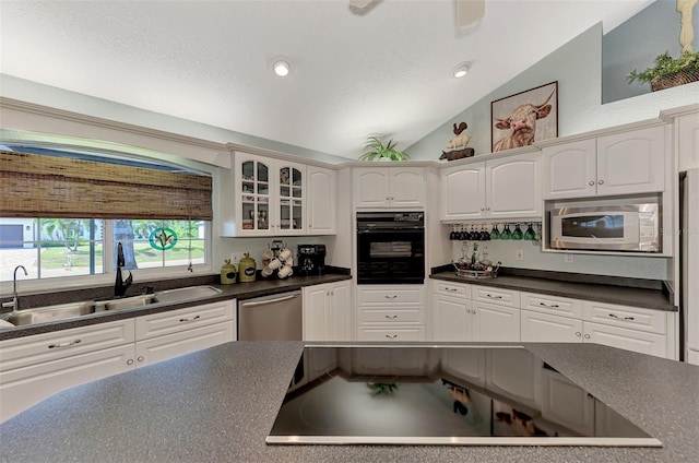 kitchen featuring oven, a sink, dark countertops, white microwave, and dishwasher