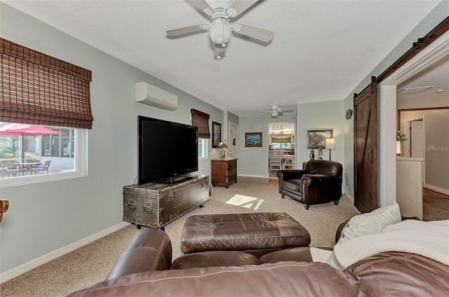 carpeted living area with baseboards, ceiling fan, an AC wall unit, and a barn door