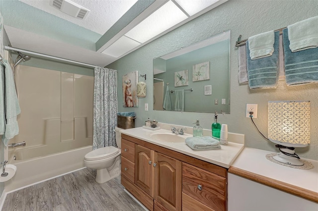 full bath featuring visible vents, toilet, wood finished floors, shower / bath combination with curtain, and vanity