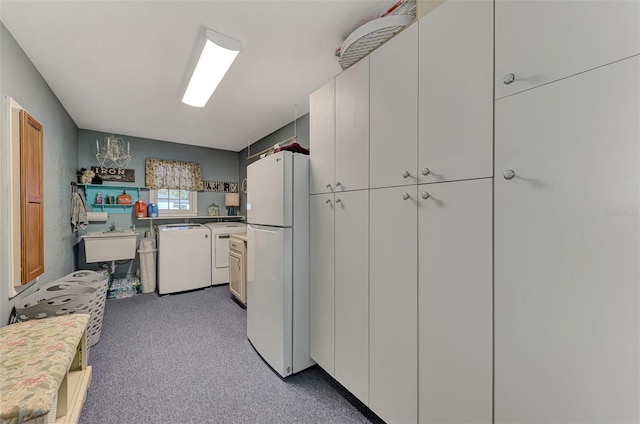 kitchen featuring light countertops, carpet, freestanding refrigerator, and washer and clothes dryer