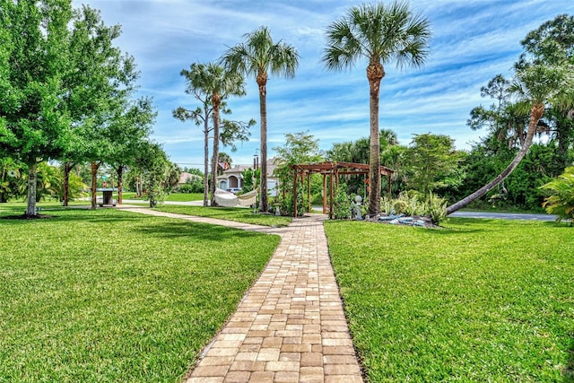 view of property's community with a lawn and a pergola