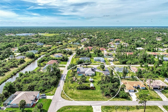 birds eye view of property featuring a forest view, a water view, and a residential view