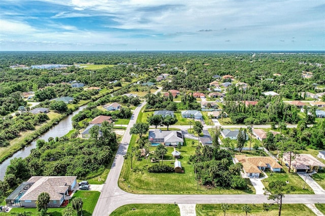 drone / aerial view with a residential view, a water view, and a wooded view