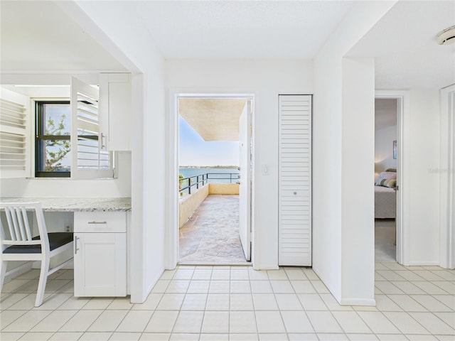 hall with light tile patterned floors and baseboards