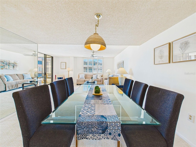 dining room featuring a ceiling fan, baseboards, carpet floors, and a textured ceiling