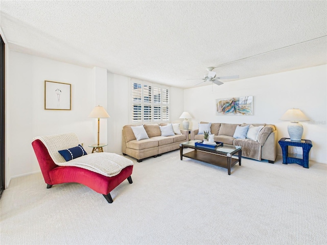 carpeted living area with a ceiling fan and a textured ceiling