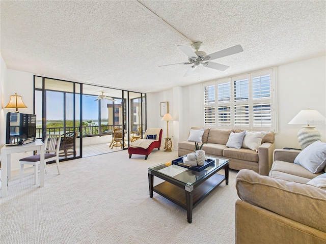 carpeted living room featuring expansive windows, a textured ceiling, and a ceiling fan