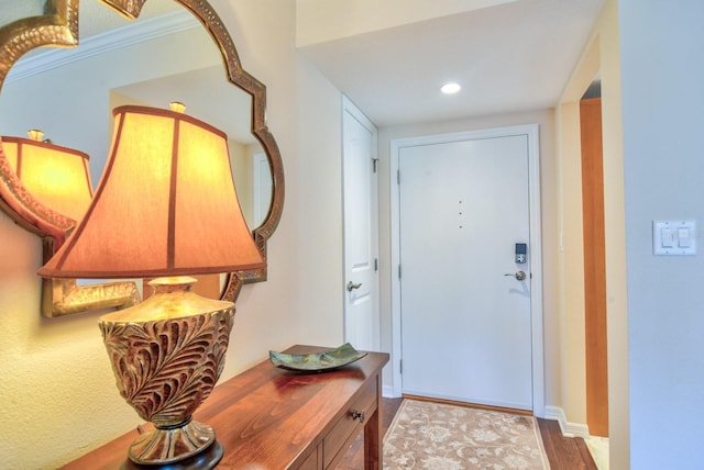 foyer featuring recessed lighting, baseboards, wood finished floors, and ornamental molding