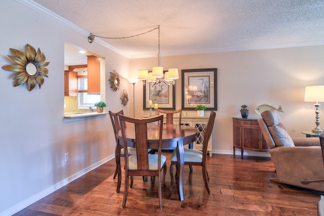 dining room with a textured ceiling, crown molding, and hardwood / wood-style floors