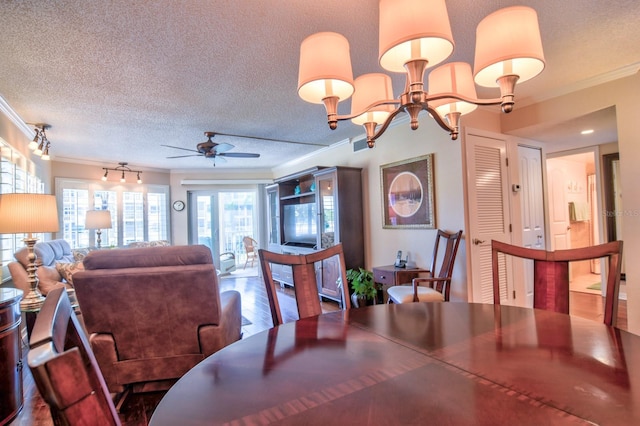 dining space with a textured ceiling, wood finished floors, crown molding, and ceiling fan with notable chandelier