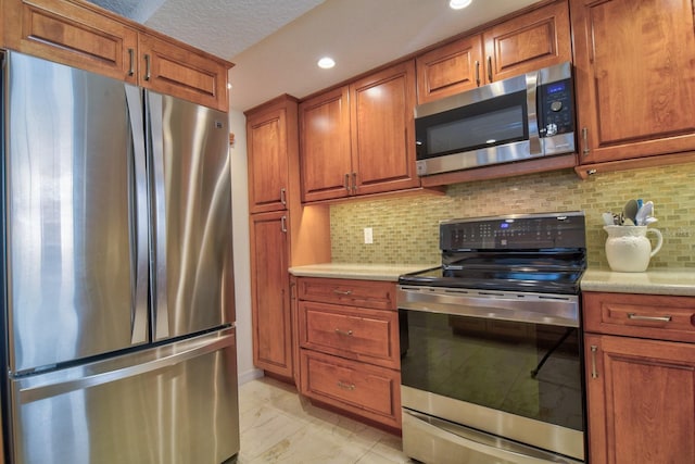 kitchen featuring decorative backsplash, brown cabinetry, marble finish floor, and appliances with stainless steel finishes