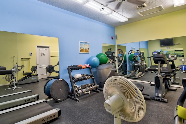 workout area featuring visible vents, a textured ceiling, and attic access