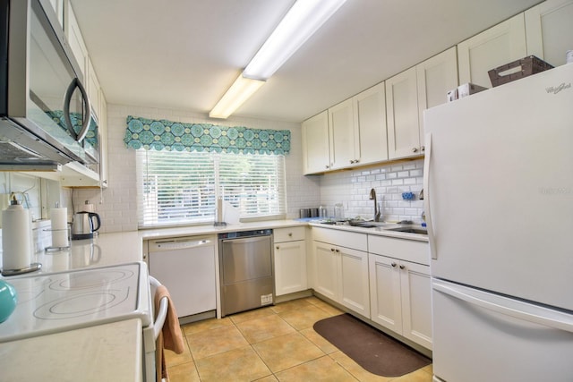 kitchen with tasteful backsplash, white cabinets, stainless steel appliances, and light countertops