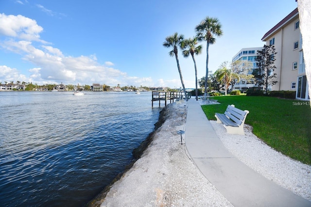 view of dock featuring a lawn and a water view