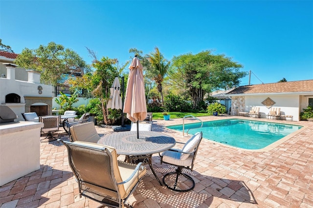 view of swimming pool featuring a patio area, outdoor dining space, and a fenced in pool