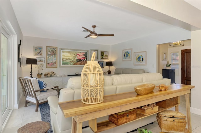 living room with light tile patterned floors, a ceiling fan, and baseboards