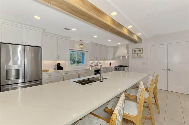 kitchen with beam ceiling, custom range hood, a sink, stainless steel appliances, and decorative backsplash