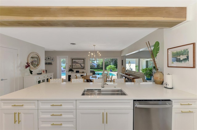 kitchen with a sink, stainless steel dishwasher, light countertops, and white cabinetry