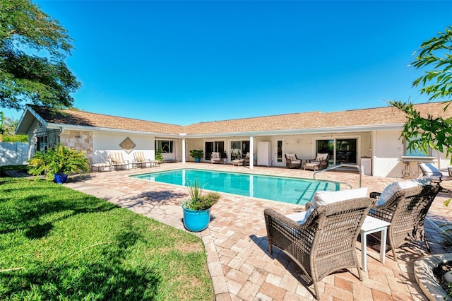 outdoor pool with a lawn, outdoor lounge area, and a patio