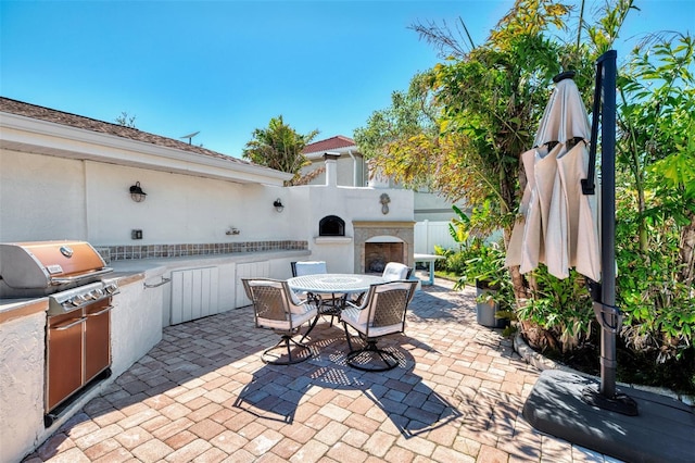 view of patio / terrace featuring exterior kitchen, outdoor dining area, and grilling area