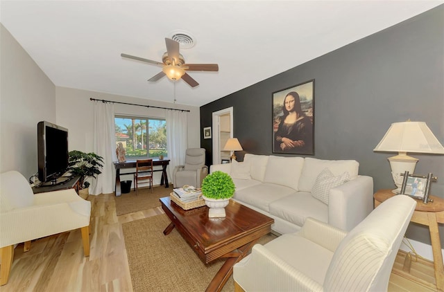 living room featuring visible vents, light wood-style flooring, and ceiling fan