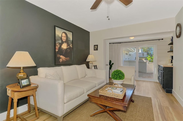 living area featuring light wood-style flooring and ceiling fan