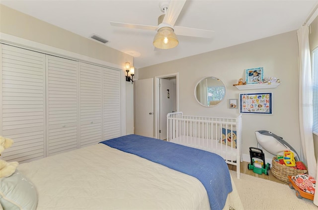 bedroom featuring a ceiling fan, visible vents, and a closet