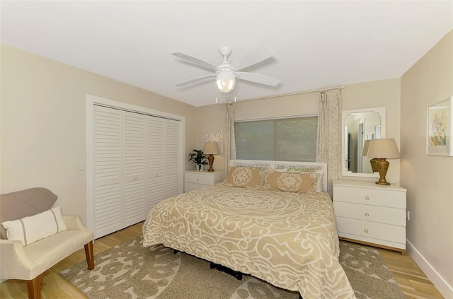 bedroom with a closet, ceiling fan, baseboards, and wood finished floors