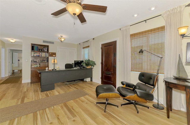 interior space with visible vents, baseboards, light wood-type flooring, and ceiling fan