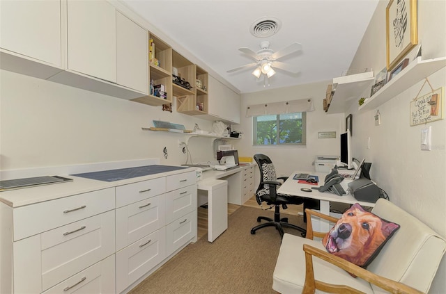 office space with visible vents, light colored carpet, and ceiling fan