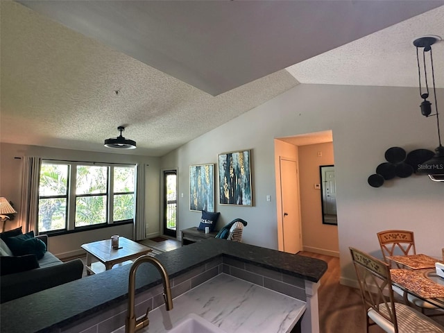 kitchen with open floor plan, a textured ceiling, dark wood-type flooring, and lofted ceiling