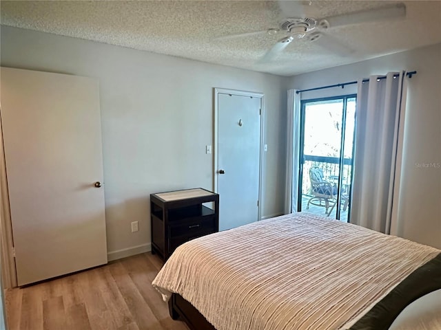 bedroom with ceiling fan, baseboards, light wood finished floors, and a textured ceiling