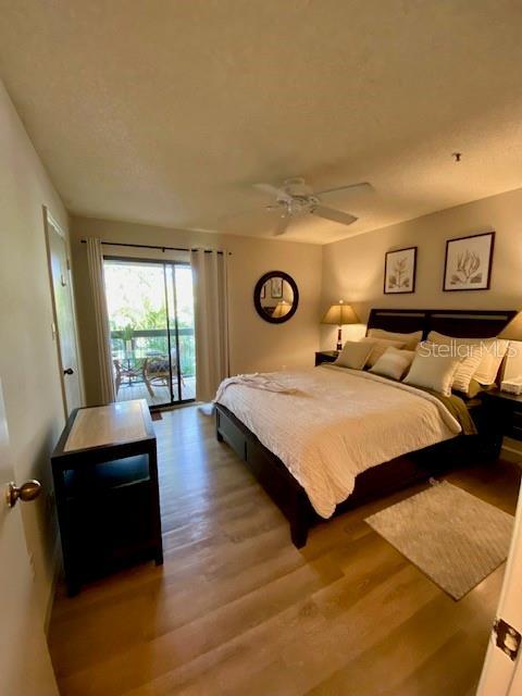 bedroom with wood finished floors, a ceiling fan, and access to exterior