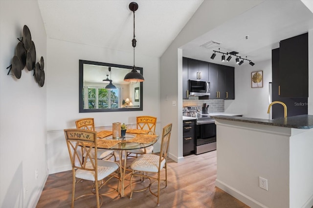 dining area with visible vents, baseboards, and track lighting