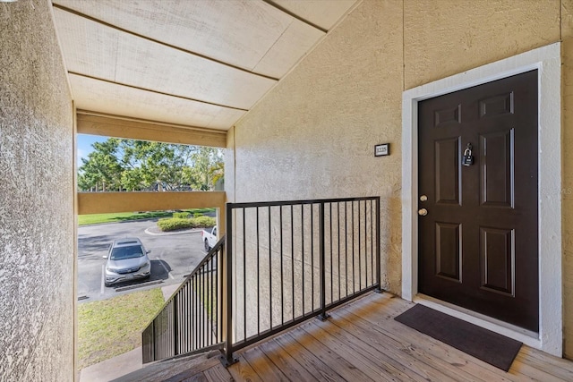 property entrance featuring stucco siding and a balcony
