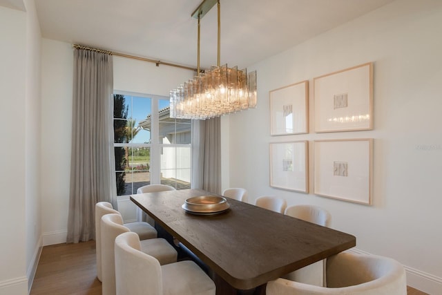 dining room with wood finished floors, baseboards, and a chandelier