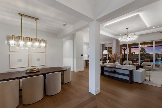 dining area with visible vents, baseboards, an inviting chandelier, and wood finished floors