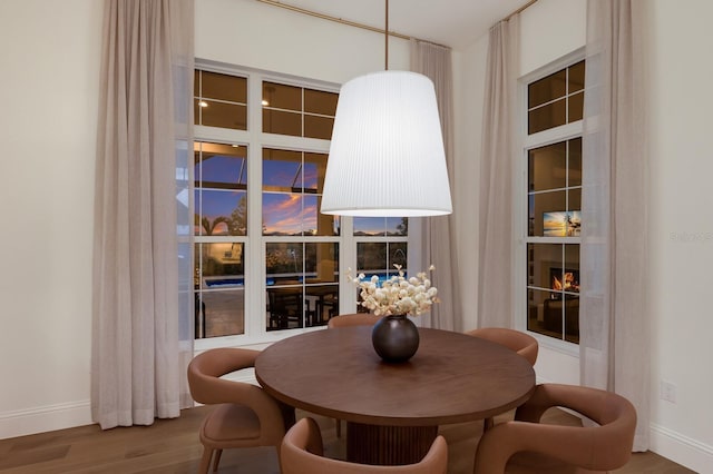 dining area with baseboards and wood finished floors