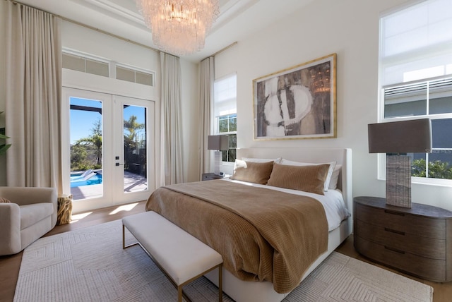 bedroom with a chandelier, multiple windows, french doors, and access to outside