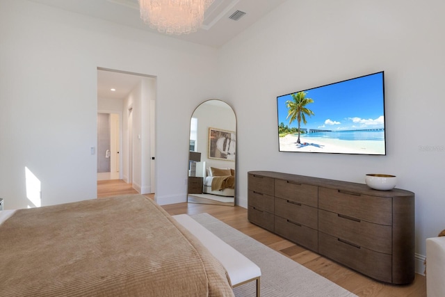 bedroom featuring a chandelier, visible vents, light wood-style flooring, and baseboards