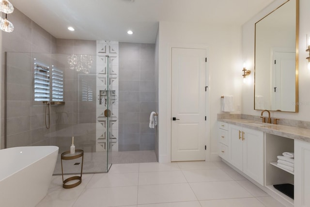 bathroom with a freestanding tub, a walk in shower, recessed lighting, tile patterned flooring, and vanity