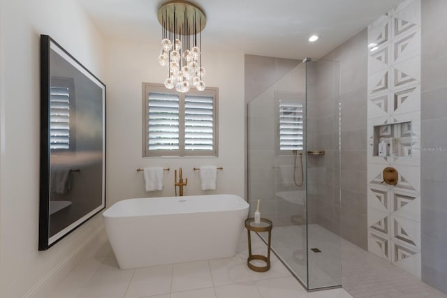 bathroom featuring tile patterned flooring, a walk in shower, recessed lighting, an inviting chandelier, and a freestanding tub