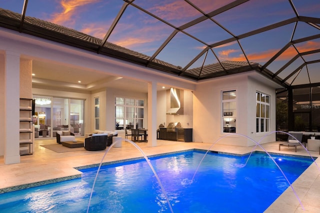 pool at dusk with a patio, area for grilling, and outdoor lounge area