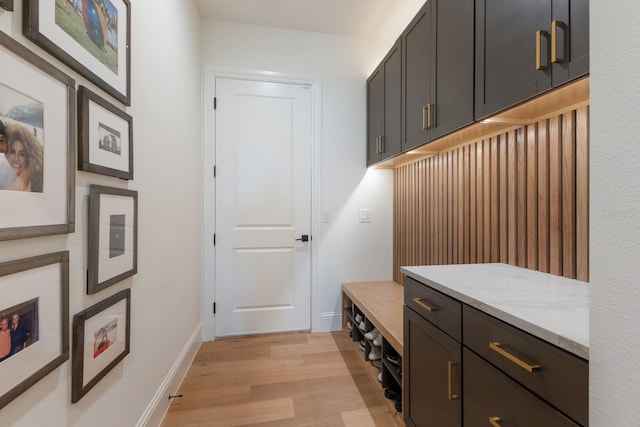 mudroom featuring baseboards and light wood-style floors