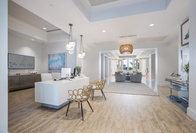 office space with light wood-type flooring, visible vents, recessed lighting, baseboards, and a raised ceiling